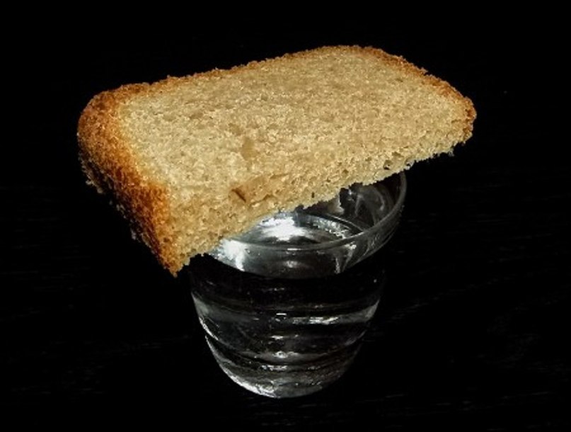 Ставят стакан воды и хлеб. Стопка с хлебом.